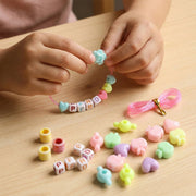 Close-up of colourful beads and elastic thread in kids jewellery kit