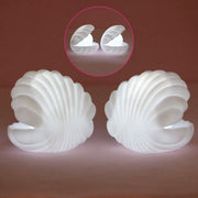 A child's hand reaching for the gentle glow of the Pearl Shell Night Lamp.