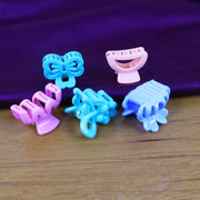 Mini hair claw clips in mixed vibrant colours scattered on a surface.