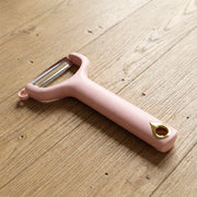 Close-up view of ergonomic handheld vegetable peeler with sharp blade
