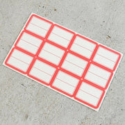 Close-up view of red and white rectangular self-adhesive label stickers