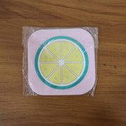 Stacked silicone fruit coasters including lemon design for table protection
