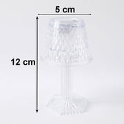 Small crystal table lamp creating a warm, ambient glow in a dark room.