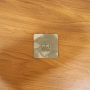 Transparent adhesive wall hook in a real-life home setting, holding various items.