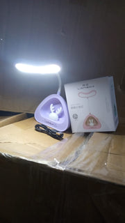 Compact LED desk light with button control on a clean workspace.