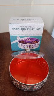 Round silver dry fruit box displayed for home serving on a table.