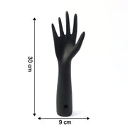 Black hand jewelry display stand placed on shelf for accessories