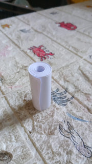 An overhead view of the thermal printer paper roll and a mini printer on a workspace.