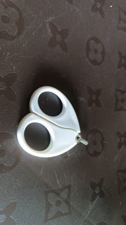 Close-up of baby safety nail cutter scissors showing circular blade