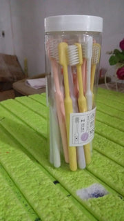 The complete 20-piece soft plastic toothbrush set with its clear portable round storage box.