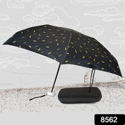An open black umbrella with gold musical notes stands beside its closed black case on a sketched outdoor scene.