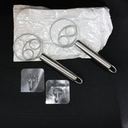 Two stainless steel spiral hand whisks placed on kitchen countertop